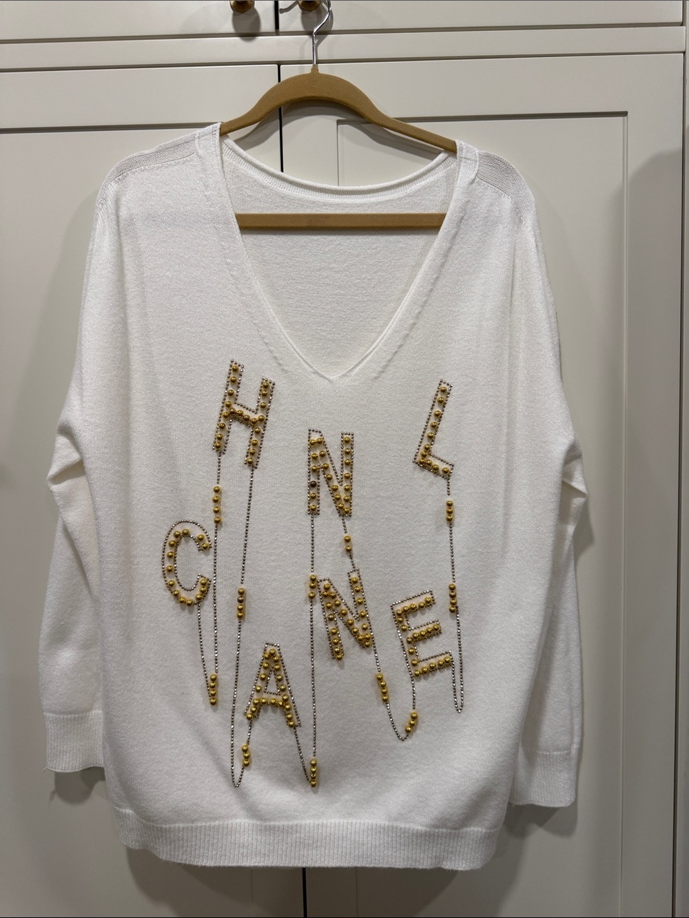 White V-Neck Sweater with Gold Beaded Lettering Accent
